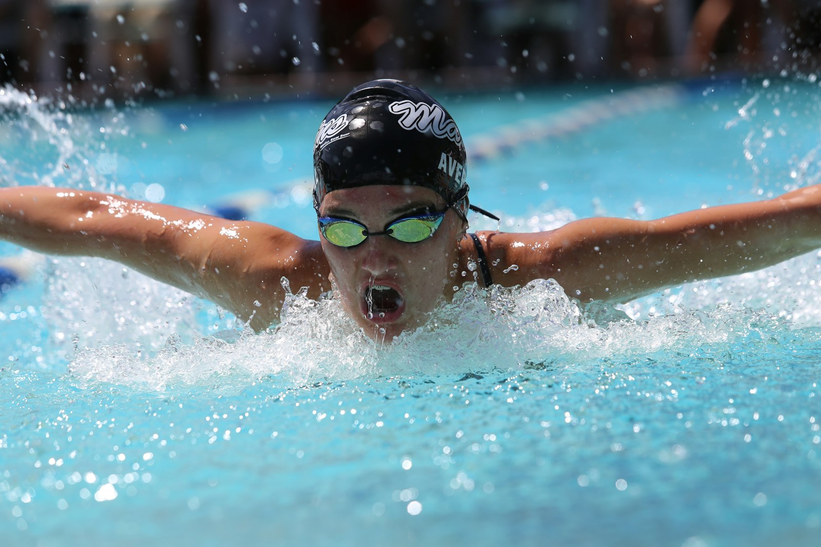 Swimmer wearing clear, fog-free swim goggles in an indoor pool