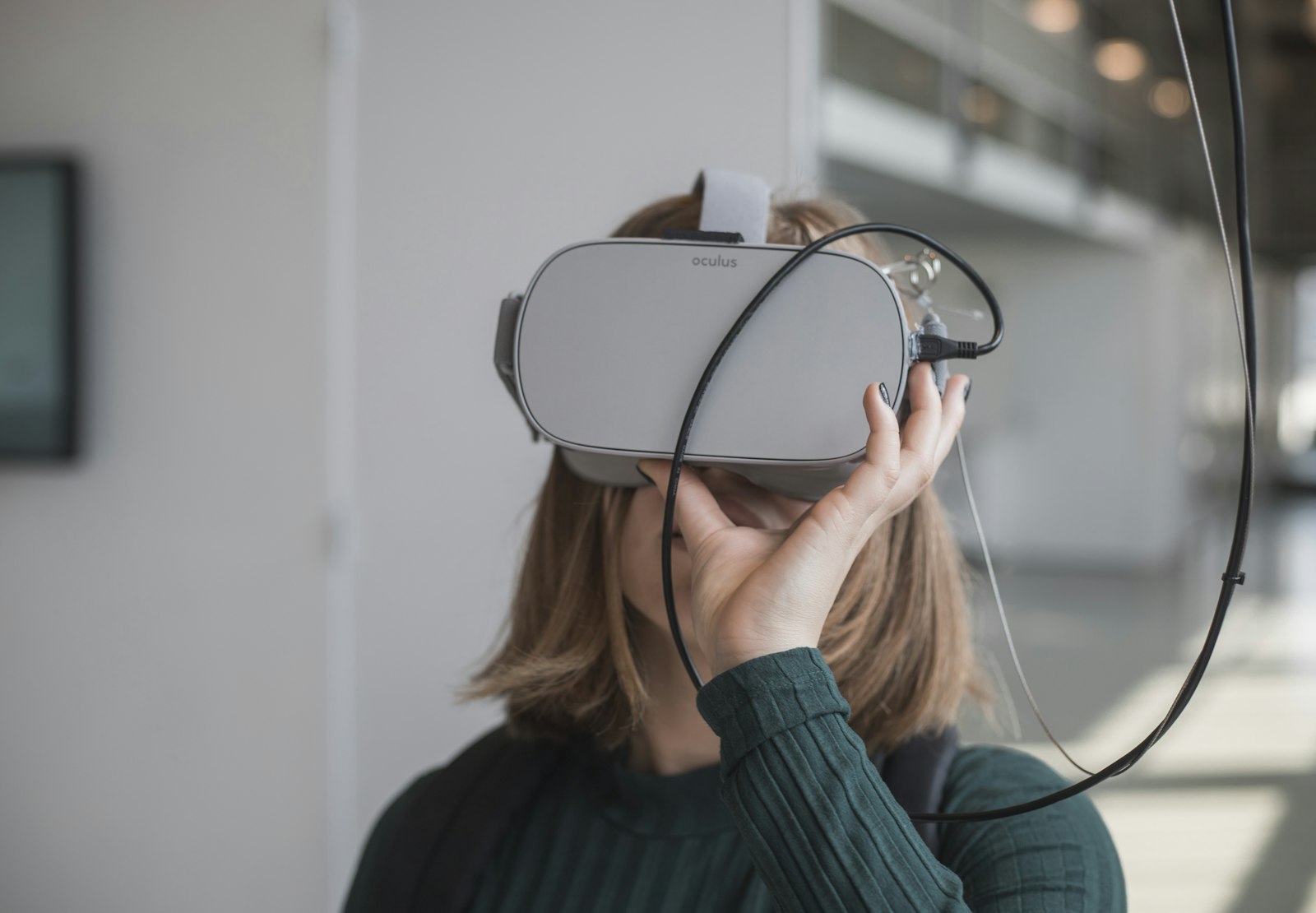 Person holding a white and black VR headset, showing the inner lenses that fog during play.